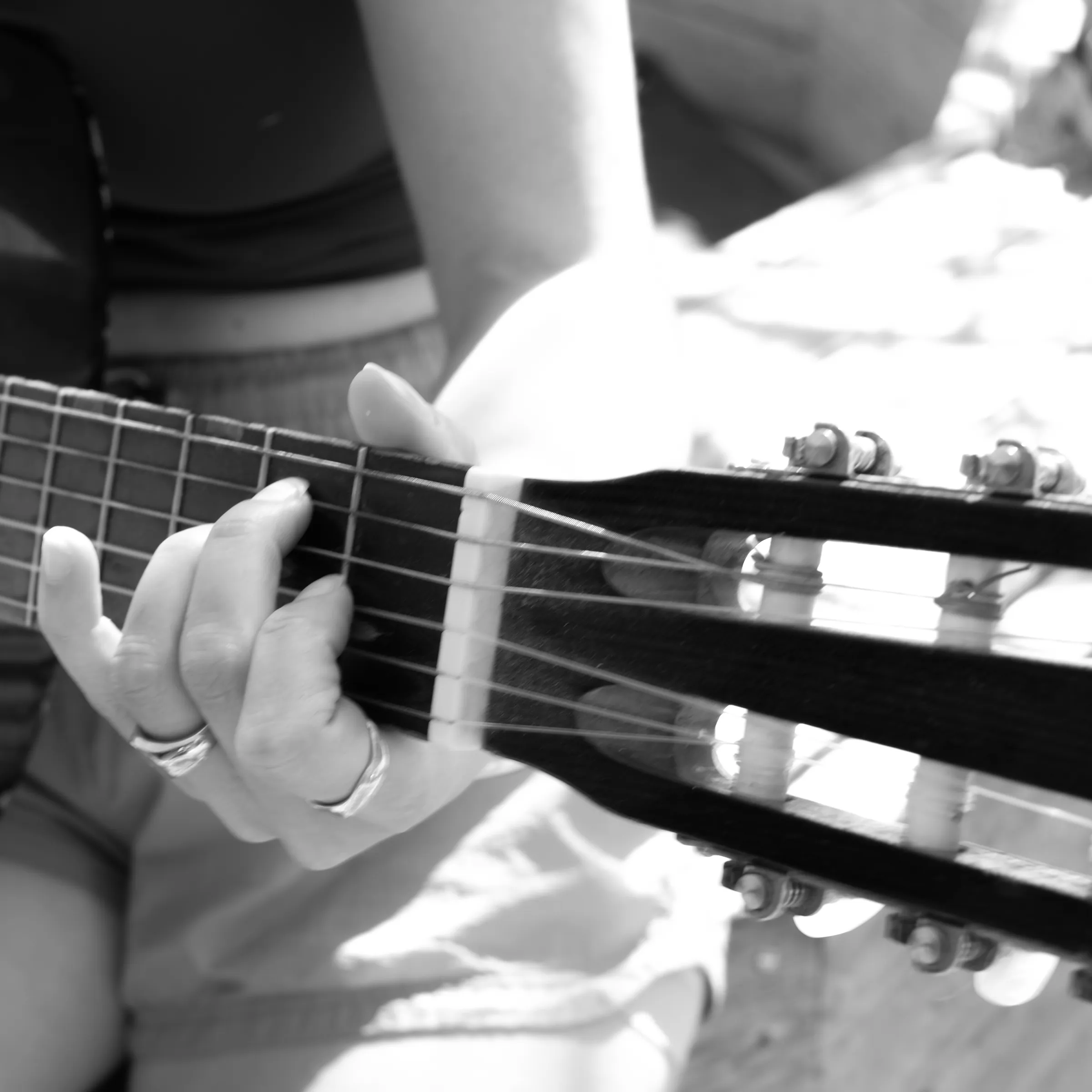 A person playing guitar during a gathering at Lakefront.